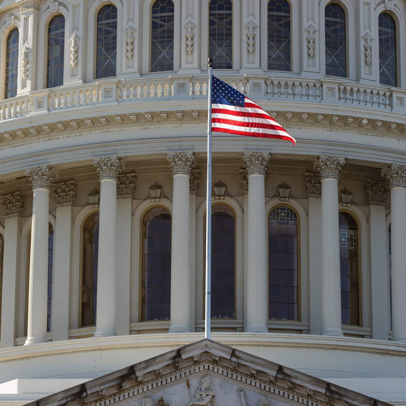 American flag on the background of the Capitol in Washington D.C.